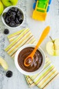 Baby food. Homemade puree of green apples and prunes in a white bowl on a wooden light background. Healhy food.