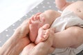 Baby foot in mom`s hands. massage concept for babies. The feet of a tiny newborn baby on a female hand shape close up Royalty Free Stock Photo