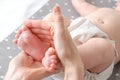 Baby foot in mom`s hands. massage concept for babies. The feet of a tiny newborn baby on a female hand shape close up Royalty Free Stock Photo