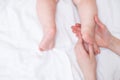 Baby feet on a female hand close up on white background. Mom and her child. Copy space Royalty Free Stock Photo