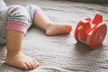 Baby foot and red toy on the bed Royalty Free Stock Photo