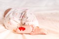 Baby foots with hearts on their feet. A newborn baby is lying on