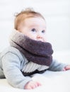 Baby in a frey knitted sweater and big brown scarf Royalty Free Stock Photo