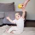 Baby gets an apple from mother. Mother gives to daughter her first food Royalty Free Stock Photo