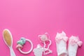 Baby girl accessories soother, wooden toy, socks and teether on pink background with copy space. Top view, flat lay Royalty Free Stock Photo