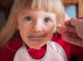 Baby girl being fed by hand. Royalty Free Stock Photo