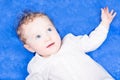 Baby girl with big blue eyes on blue blanket Royalty Free Stock Photo