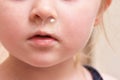 Baby girl and big bubble of snot from nose close up. Royalty Free Stock Photo