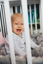 Baby girl with blue eyes and blond hair is crying in her bed Royalty Free Stock Photo