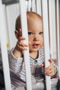 Baby girl with blue eyes and blond standing in her bed, close up on eyes Royalty Free Stock Photo