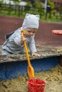 Baby girl boy 1 year old in a hat playing in the sandbox with a shovel and bucket Royalty Free Stock Photo