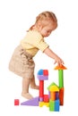 Baby girl building from toy blocks.