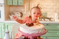 Baby girl with a cake in kitchen at home. family home two years birthday. Royalty Free Stock Photo