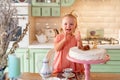 Baby girl with a cake in kitchen at home. family home two years birthday. Royalty Free Stock Photo