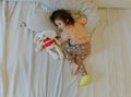 A baby girl with a cast on her leg lies on the bed. Royalty Free Stock Photo