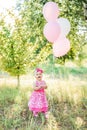 Baby girl celebrating her first bithday with gourmet cake and balloons. childrens day