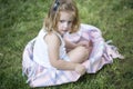 Baby girl child sitting on green grass on spring lawn. Little kids walking in the park. Royalty Free Stock Photo