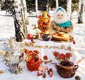 Baby girl in coat and headscarf in the Russian samovar in the ba