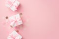 Baby girl concept. Top view photo of white gift boxes with ribbon bows and shiny confetti on isolated pastel pink background with Royalty Free Stock Photo