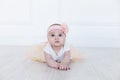 A baby girl is crawling along the floor with an inquisitive and wondering look on her face. Horizontal shot. Cute 6 months girl Royalty Free Stock Photo