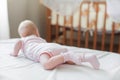 The baby girl crawls on the white bed Royalty Free Stock Photo