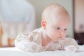 The baby girl crawls on the white bed Royalty Free Stock Photo