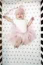 Baby girl cries in bed with a fluffy pink skirt. capricious child. crying baby top view Royalty Free Stock Photo