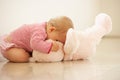 Baby Girl Cuddling Pink Teddy Bear At Home