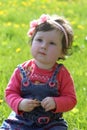 Baby girl among dandelion lawn Royalty Free Stock Photo