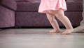 Baby girl doing first steps in her life. Infant learning walk. Little feet step Royalty Free Stock Photo