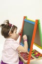 Baby girl drawing on black board with chalk Royalty Free Stock Photo