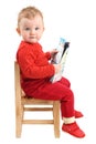 Baby girl dressed in red sitting on chair reading