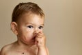 Baby girl eating berries, messy face, one year old. Portrait close up Royalty Free Stock Photo