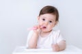 Baby girl eating blend mashed food sitting, on high chair, mother feeding child, hand with spoon for vegetable lunch Royalty Free Stock Photo