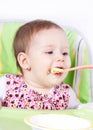 Baby girl eating in her chair Royalty Free Stock Photo