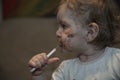 baby girl eating her chocolate desert with a spoon and making a mess Royalty Free Stock Photo