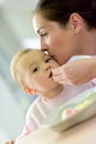 Baby girl eating lunch with her mother helping her Royalty Free Stock Photo