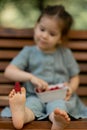 Baby girl eating raspberry on picnic and put on feet. Royalty Free Stock Photo