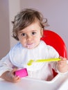 Baby girl eating yogurt with messy face Royalty Free Stock Photo