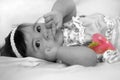 Baby girl with finger in her mouth and strawberry Royalty Free Stock Photo