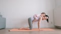 Baby girl fun and sits on her mother`s back who exercises on yoga mat at home Royalty Free Stock Photo