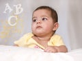 Baby girl gazing at letters and dazzle Royalty Free Stock Photo