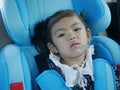 A baby girl getting bored sitting in a car seat and waiting to arrive at a destination