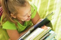 Baby girl with glasses on the bed reads.