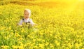 Baby girl on a green meadow with yellow flowers Royalty Free Stock Photo