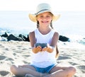 Baby girl in hat playing with sand on sea coast in summer Royalty Free Stock Photo