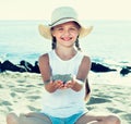 Baby girl in hat playing with sand on sea coast in summer Royalty Free Stock Photo