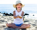 Baby girl in hat playing with sand on sea coast in summer Royalty Free Stock Photo