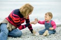 Baby girl and her mother playing on the beach Royalty Free Stock Photo