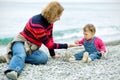 Baby girl and her mother playing on the beach Royalty Free Stock Photo